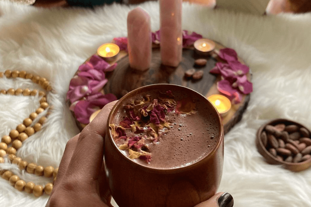 Cacao ceremonie thuis met ceremoniële cacao, kaarsen en rozen als ritueel voor ontspanning en zelfliefde