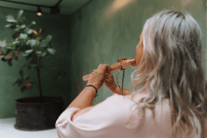 Muziek tijdens Choco Bliss ceremonie vrouw speelt ceremonieel instrument voor innerlijk werk
