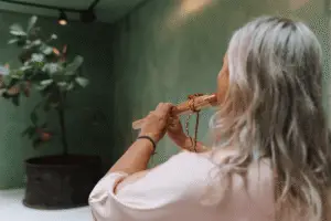 Muziek tijdens Choco Bliss ceremonie vrouw speelt ceremonieel instrument voor innerlijk werk